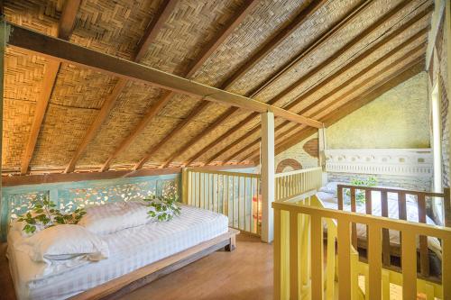 日惹ETHES Coworking - Coliving & Lounge的一间设有一张床铺的卧室,位于一个拥有木制天花板的房间