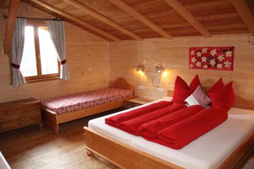 麦尔迪娜诺伊舍茨霍夫酒店的一间卧室配有一张带红色床单的床和一扇窗户。