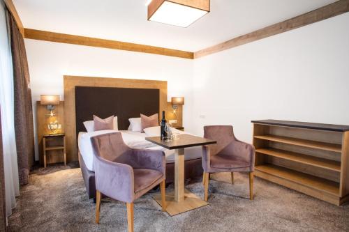 伊施格尔圣尼古劳斯酒店的卧室配有一张床和一张桌子及椅子
