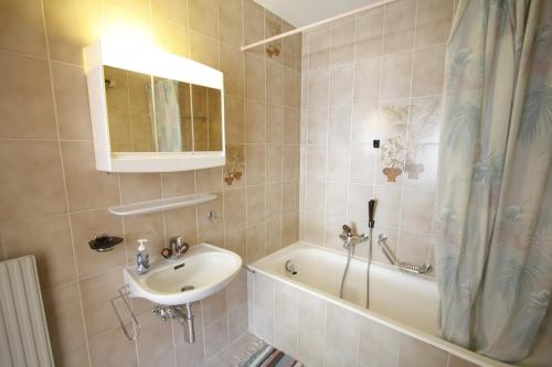 克莱恩 蒙塔纳Apartment Victoria的一间带水槽、浴缸和镜子的浴室