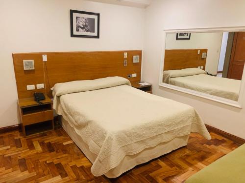 科尔多瓦Hotel Petit的一间卧室设有两张床和大镜子