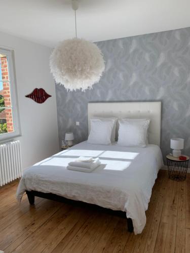 滨海迪沃VILLA CATHY Chambres d hôtes的卧室配有一张大白床和大灯