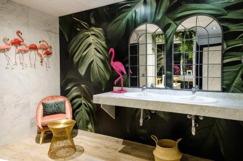 马德里克莱门特巴拉哈斯酒店的浴室设有两个水槽和粉红色火烈鸟壁画