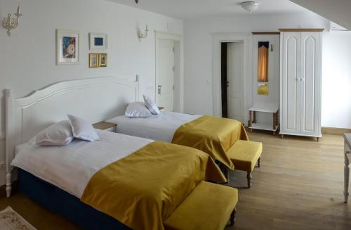 MăneciuHotel Coquette的酒店客房带两张带黄床单的床