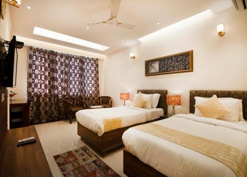 古尔冈富通帝国公寓的酒店客房设有两张床和窗户。