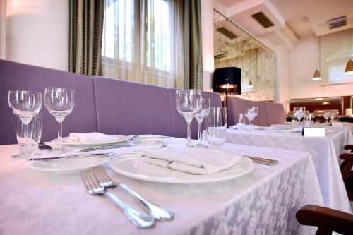波德戈里察子牙酒店的一张桌子,上面有白色的桌布和酒杯