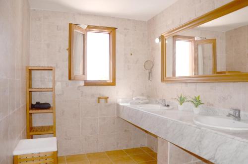 查德尔帕罗奥B16-Dúplex luminoso+ piscina a 150 m del mar的白色的浴室设有两个盥洗盆和窗户。
