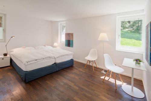 采尔马特阿尔特斯木屋 - 尊贵公寓的白色卧室配有床和桌椅