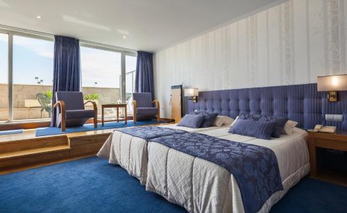 波尔图博维斯塔酒店的一间卧室设有一张大床和一个大窗户