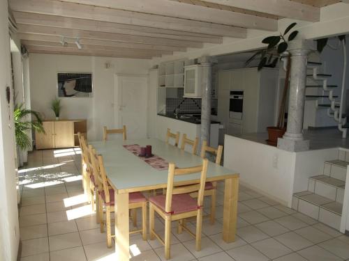 NesslauZwinglis Ferienwohnung的厨房以及带桌椅的用餐室。