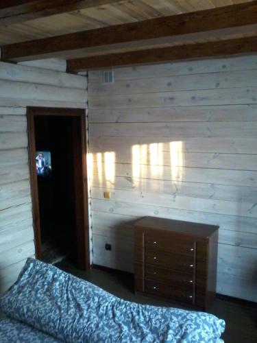 VulʼkaЕкомотель的一间卧室设有一张床和木墙