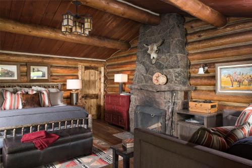 大天空市龙恩山牧场酒店的小木屋卧室配有1张床和壁炉