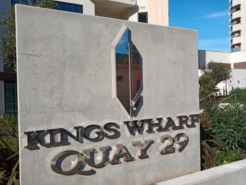 直布罗陀NEW - Kings Wharf Quay29 - Large Studio Apartment with 3 Pools - Gym - Rock Views - Holiday and Short Let Apartments in Gibraltar的建筑前的标志,有窗