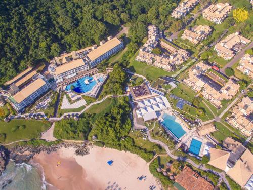 弗洛里亚诺波利斯Costao do Santinho Resort All Inclusive的享有带游泳池和海滩的度假村的空中景致
