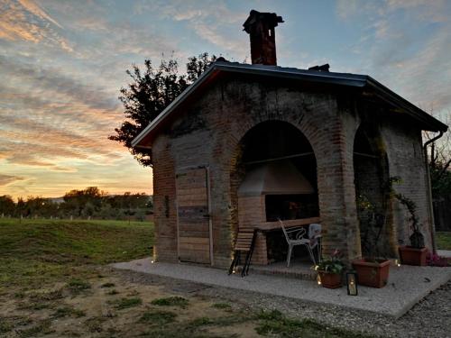 伊莫拉Agriturismo "La Fondazza"的一个小砖砌的狗屋,里面装着椅子