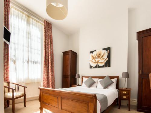 布里斯托OYO the Regency, Clifton Bristol的一间卧室设有一张大床和一个窗户。