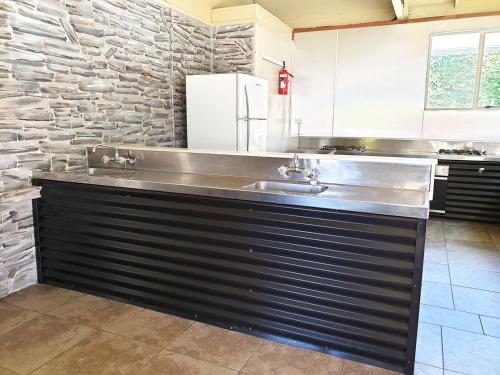 特威泽尔鲁塔尼瓦湖假日公园的厨房配有带水槽的不锈钢台面