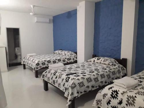 CaucasiaHOTEL TANIA的一间设有三张床和蓝色墙壁的房间
