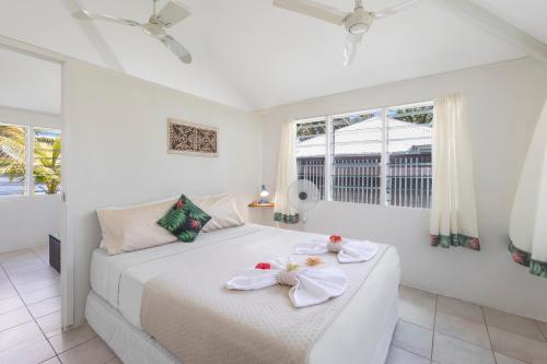 FagamaloSavaii Lagoon Resort的白色卧室,配有带毛巾的床