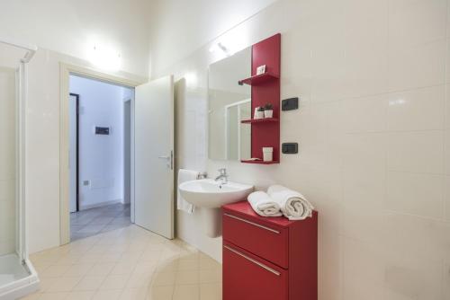 阿科拉威格纳住宅酒店的一间带水槽和红色橱柜的浴室
