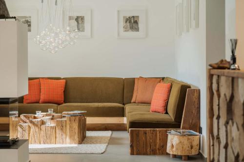 科尔蒂纳丹佩佐Camina Suite and Spa的客厅配有棕色沙发和橙色枕头
