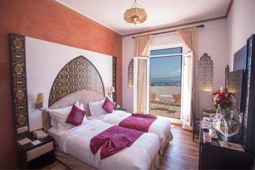 丹吉尔明萨酒店的一间卧室设有一张床和一个大窗户