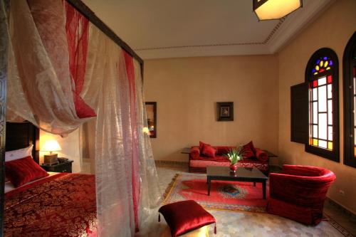 马拉喀什阿尔法希亚阿古达尔酒店的一间卧室配有一张床、一张沙发和一张桌子