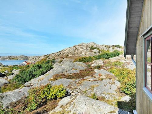 谢尔港12 person holiday home in Sk rhamn的一座位于岩石山丘上的房屋,享有海景