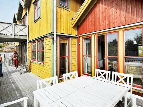 谢尔港12 person holiday home in Sk rhamn的坐在五彩缤纷建筑外的白色长凳