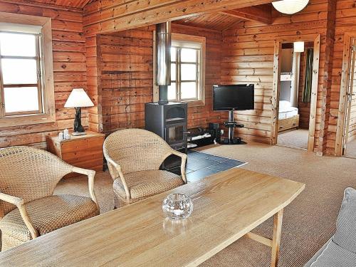 森讷维6 person holiday home in Ringk bing的客厅配有桌椅和电视。