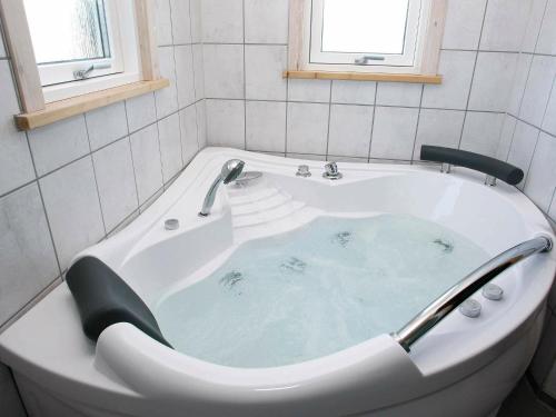 布罗斯特布罗斯特31号三卧室度假屋的浴室设有装满蓝色水的浴缸。