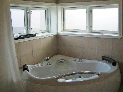 布罗艾厄Three-Bedroom Holiday home in Broager 4的带浴缸的浴室和2个窗户