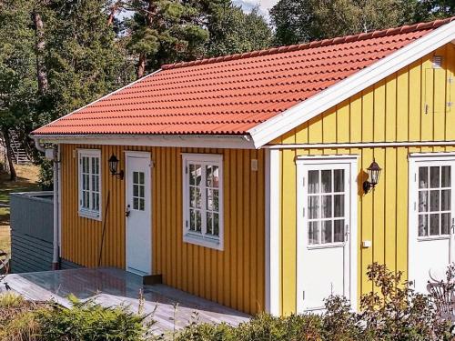 Arkösund维克博兰德两卧室度假屋 的黄色和白色的带红色屋顶的棚子