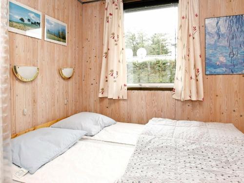 格隆霍Three-Bedroom Holiday home in Løkken 41的一间小卧室,配有床和窗户