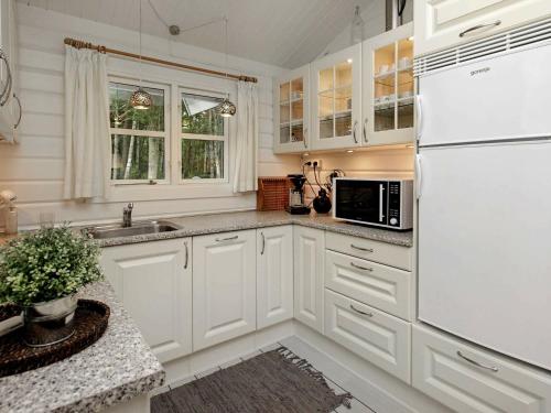 莱斯6 person holiday home in L s的厨房配有白色橱柜和白色冰箱。