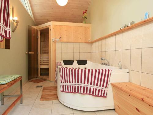 Udsholt SandThree-Bedroom Holiday home in Græsted 4的厨房配有浴缸,提供红白毛巾