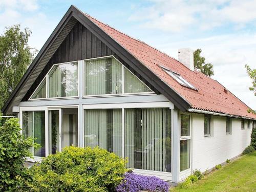 Strøby Egede4 person holiday home in K ge的一座红色屋顶和窗户的房子