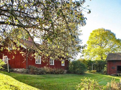Västra Tunhem8 person holiday home in Varg n的前面有院子的红色房子