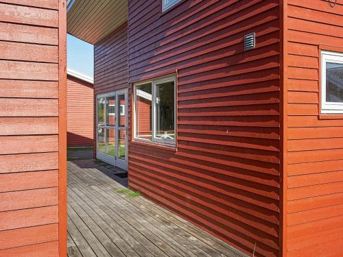 古兹耶姆6 person holiday home in Gudhjem的铺有木地板的红色房子和一座建筑