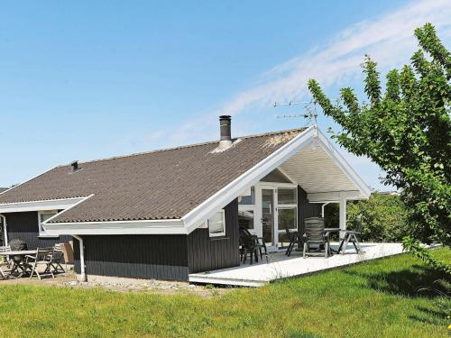 Helnæs By6 person holiday home in Ebberup的一个小房子,设有门廊和庭院