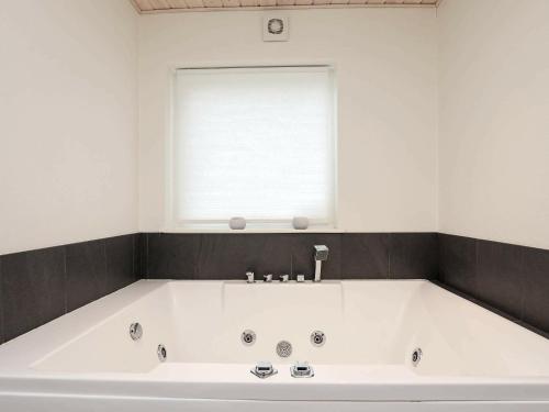 伦斯楚普9 person holiday home in Hj rring的带窗户的浴室内的白色大浴缸