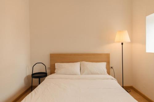 曼谷尔毕旅舍的卧室配有白色的床和灯