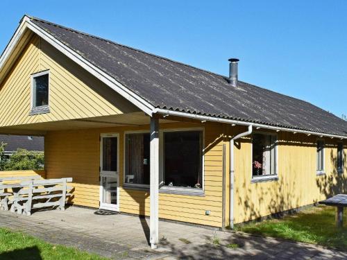 乌尔夫堡6 person holiday home in Ulfborg的一座黄色的小房子,设有太阳能屋顶