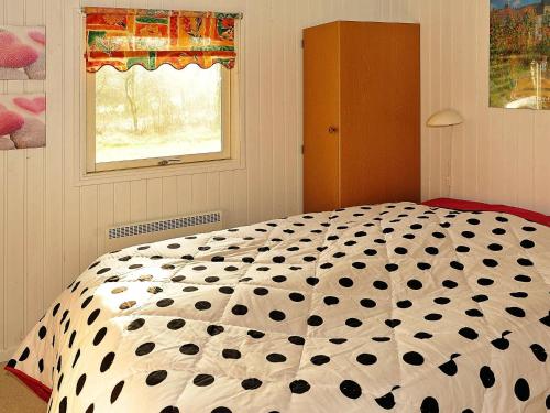 朗尼赫德Three-Bedroom Holiday home in Nørre Nebel 16的卧室配有黑色和白色的被子。