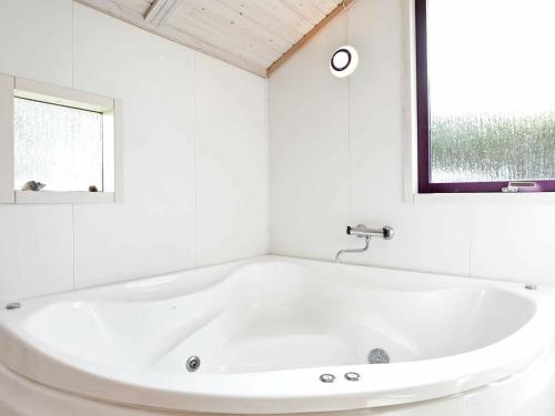 瓦伊厄斯斯特兰德8 person holiday home in Oksb l的白色浴室设有白色浴缸,配有窗户