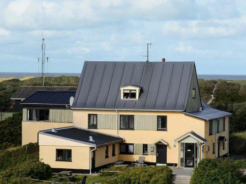 瓦伊厄斯斯特兰德4 person holiday home in Vejers Strand的黑色屋顶的大型白色房屋