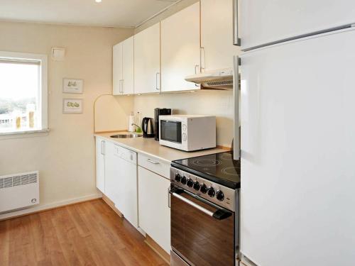 瓦伊厄斯斯特兰德4 person holiday home in Vejers Strand的厨房配有冰箱和微波炉。