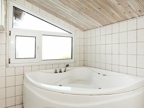 格隆霍Three-Bedroom Holiday home in Løkken 65的带窗户的浴室内的白色浴缸