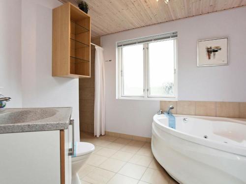 法贾德嘉德8 person holiday home in Ulfborg的带浴缸、卫生间和窗户的浴室