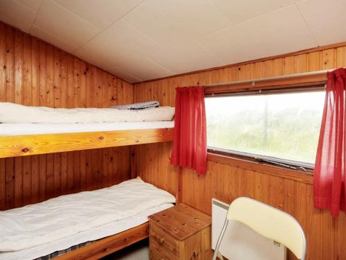 格隆霍洛肯25号两卧室度假屋的一间卧室设有两张双层床和一扇窗户。